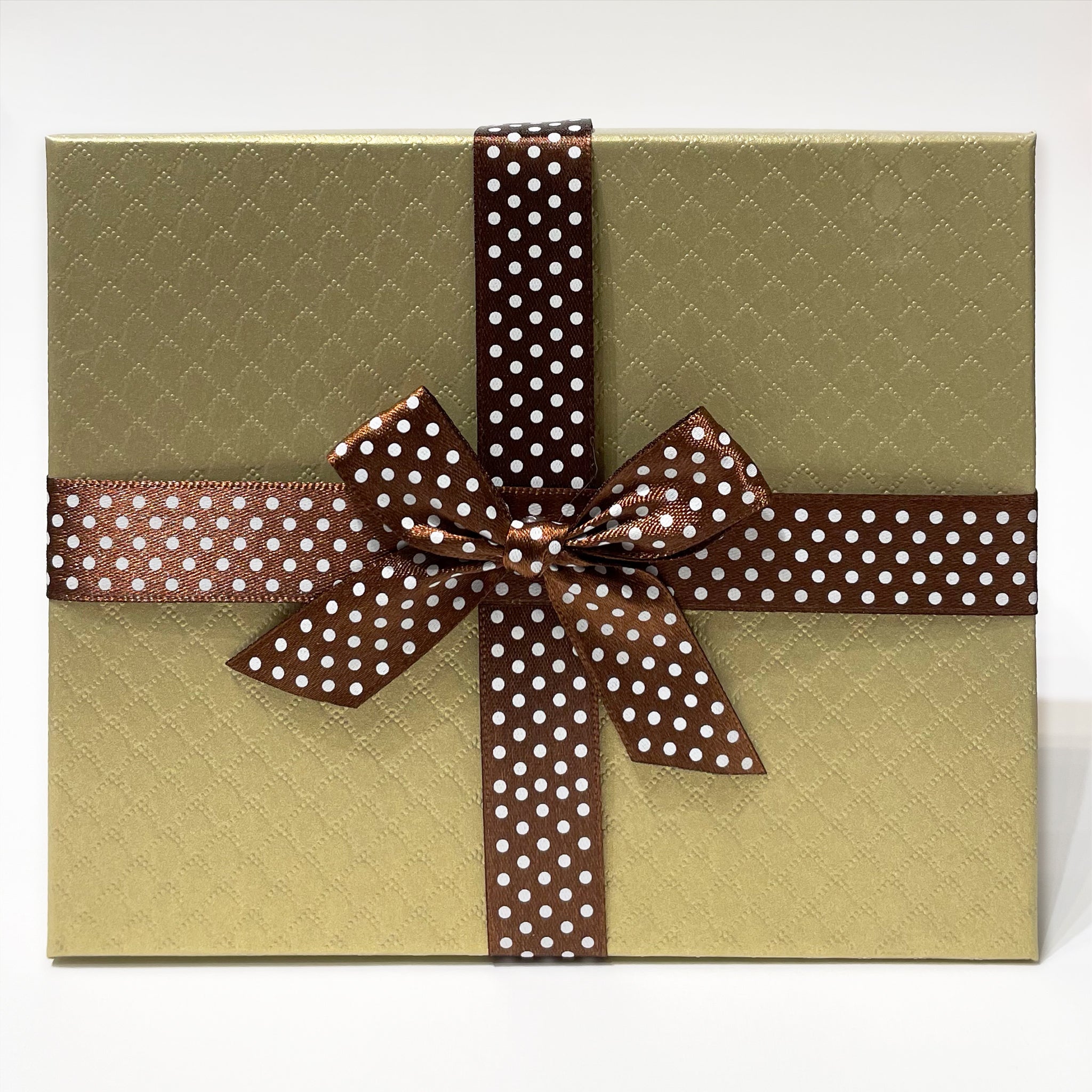 An image of a gold gift box with brown ribbon with white dots