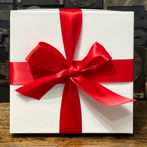 An image of a white gift box with red ribbon