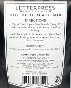 Detail photo of back of bag which reads: LetterPress Chocolate Hot Chocolate Mix, Directions: Heat up 8oz of your favorite milk (dairy, soy milk, oat milk, almond milk, etc) just below boiling. Add 1/4 cup hot chocolate mix (about 1oz) and stir thoroughly. Add more mix for richer hot chocolate! Ingredients: Organic cocoa powder, organic unrefined cane sugar.